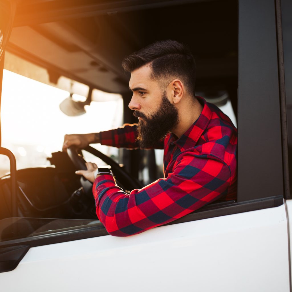 Young handsome bearded man driving his truck.